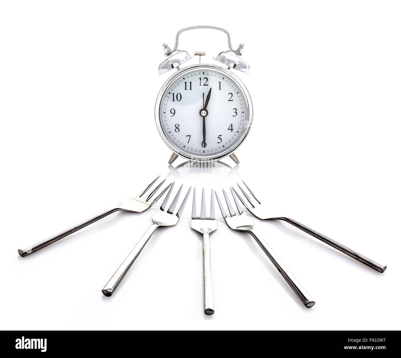 Wecker - Zeit für das Mittagessen mit Gabeln auf weißem Hintergrund Stockfoto