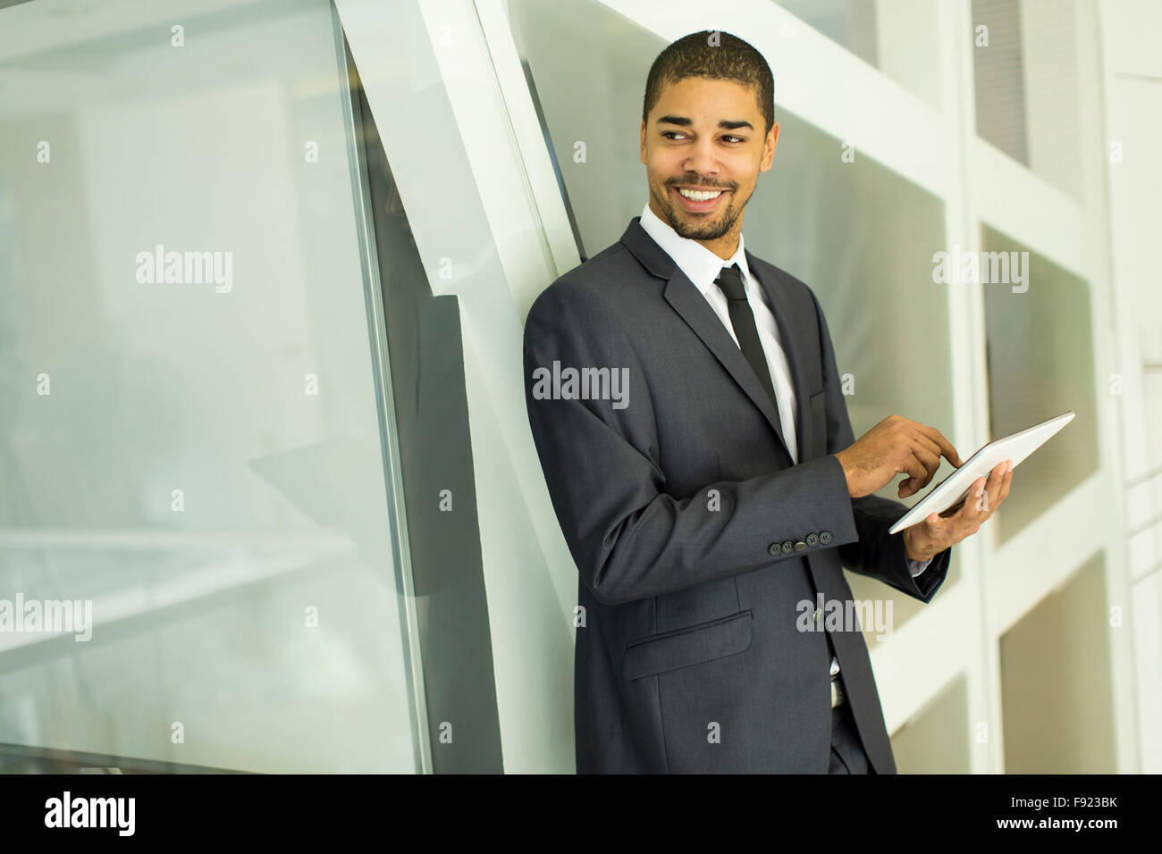 Junge schwarze Mann mit Tablet-PC im Büro Stockfoto