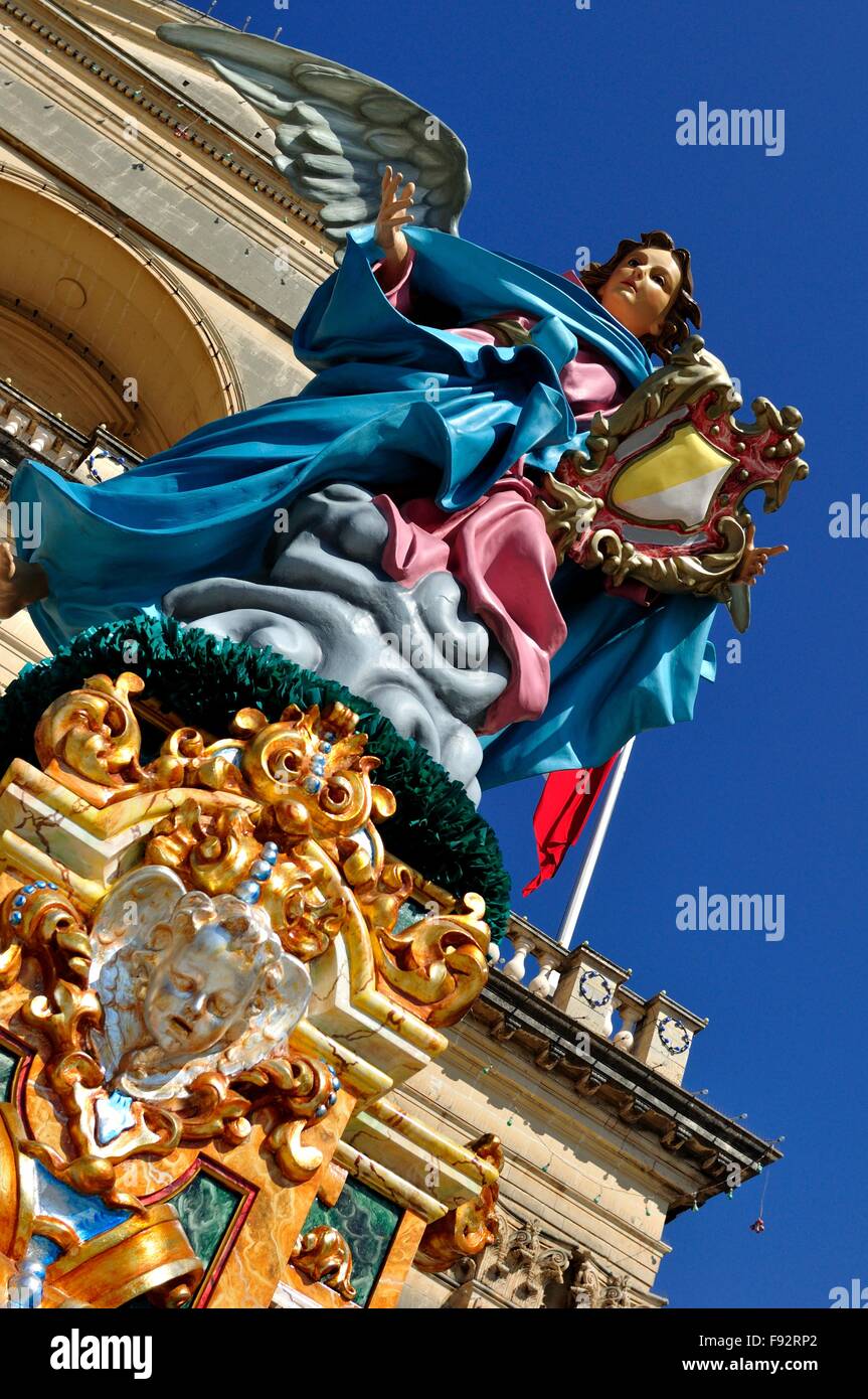 farbenfrohe Statue des geflügelten weiblichen, front Ansicht, Malteser Kirche hinter blauer Himmel Stockfoto