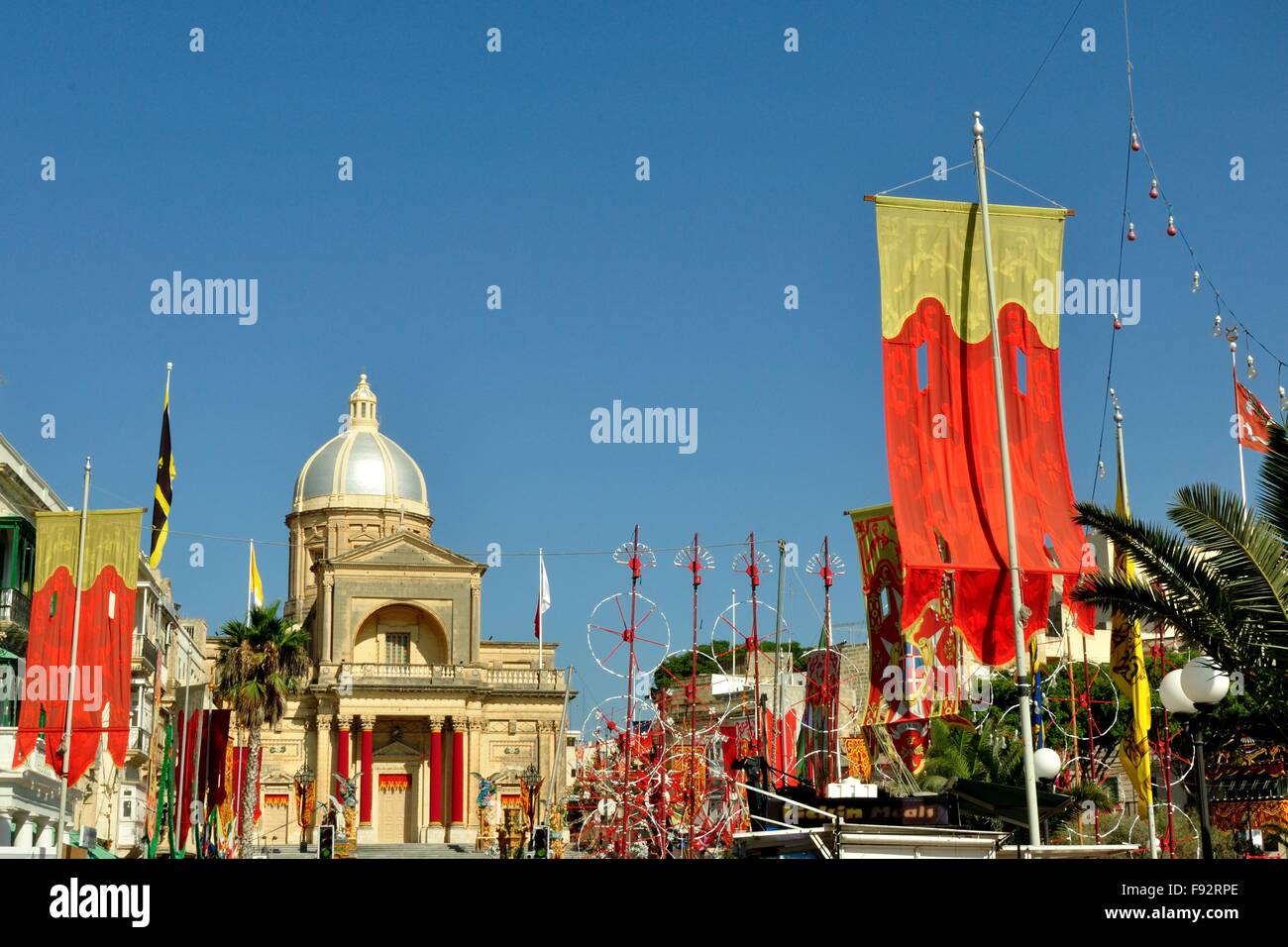 Flaggen und Feuerwerk in einem traditionellen maltesischen Dorf, eingerichtet für das jährliche Dorffest oder 'Festa'. Dies ist für das Fest des heiligen Johannes in Kalkara Stockfoto