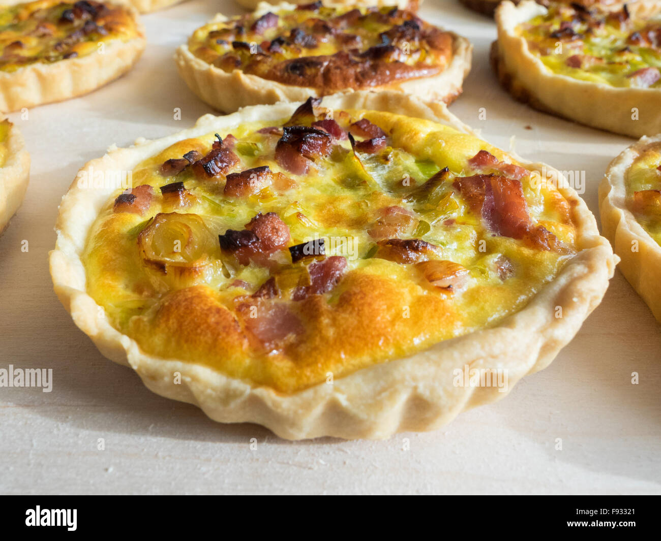 Leckere französische Quiche Lorraine u.a. auf Holzbrett Stockfotografie ...