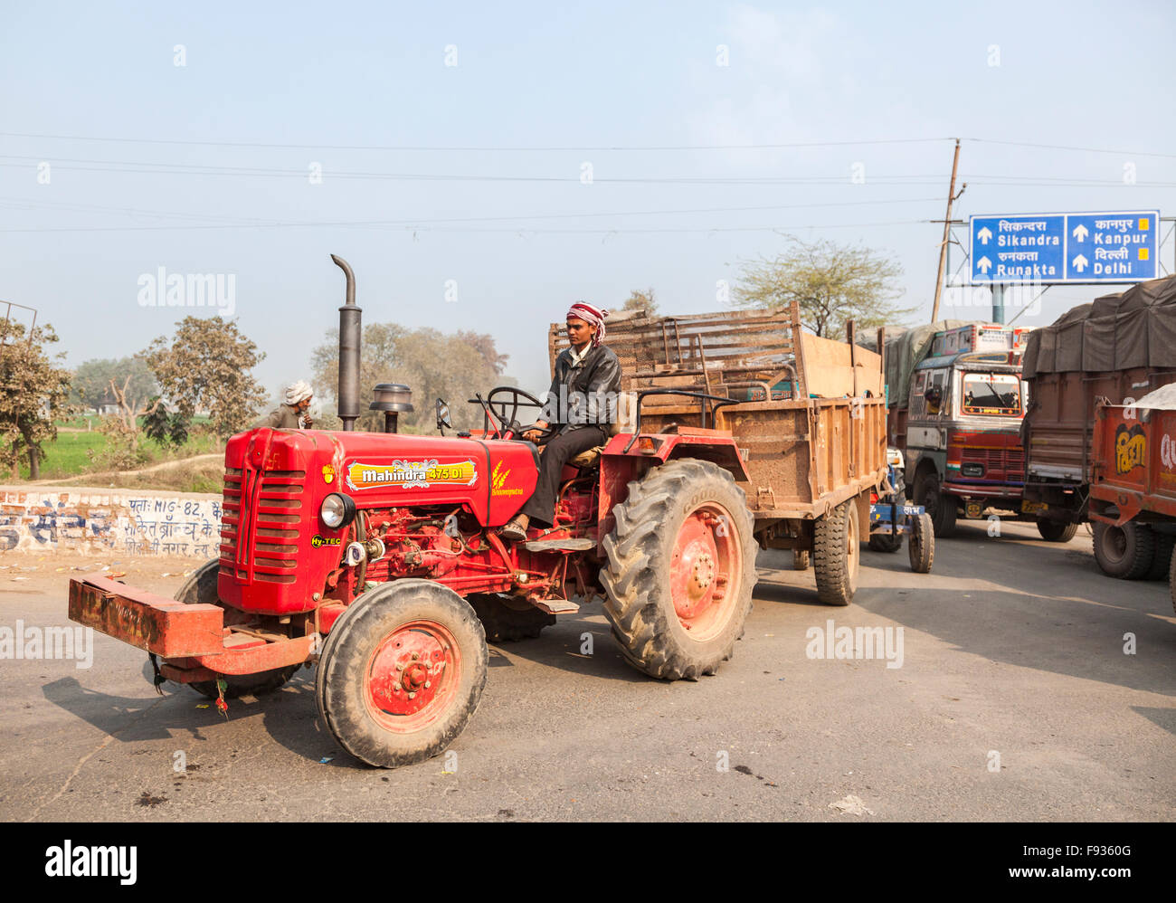 Moderner roter Traktor mit Anhänger auf einer belebten Straße in der Nähe von Fatehpur Sikri, eine Stadt in der Agra Bezirk von Uttar Pradesh, Indien Stockfoto