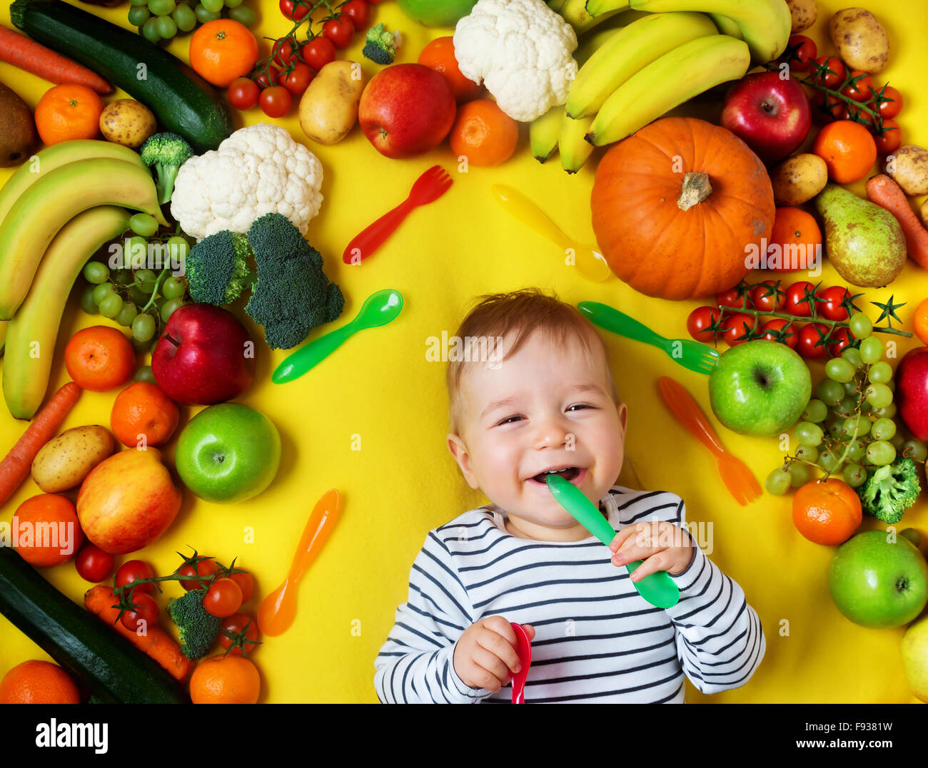 Baby, umgeben von Obst und Gemüse Stockfotografie - Alamy