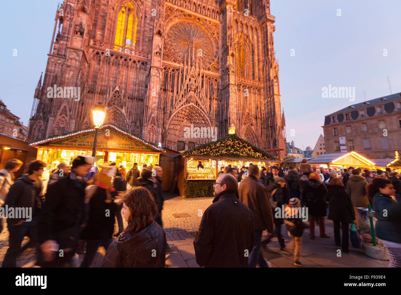 Leute einkaufen bei Ständen vor der Kathedrale von Straßburg am Abend; Straßburg Weihnachtsmarkt in Straßburg Elsass Frankreich Europa Stockfoto