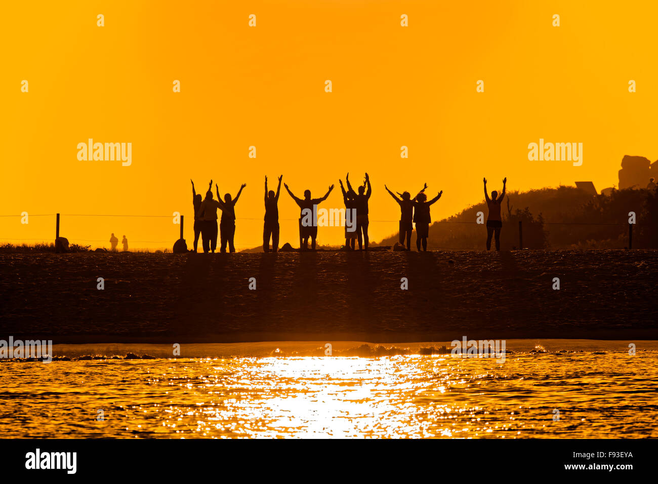 Gruppe von Menschen unter einem magischen Sonnenuntergang tun, Tai-Chi am Strand Rodas in Cíes-Inseln, Galicien, Spanien Stockfoto