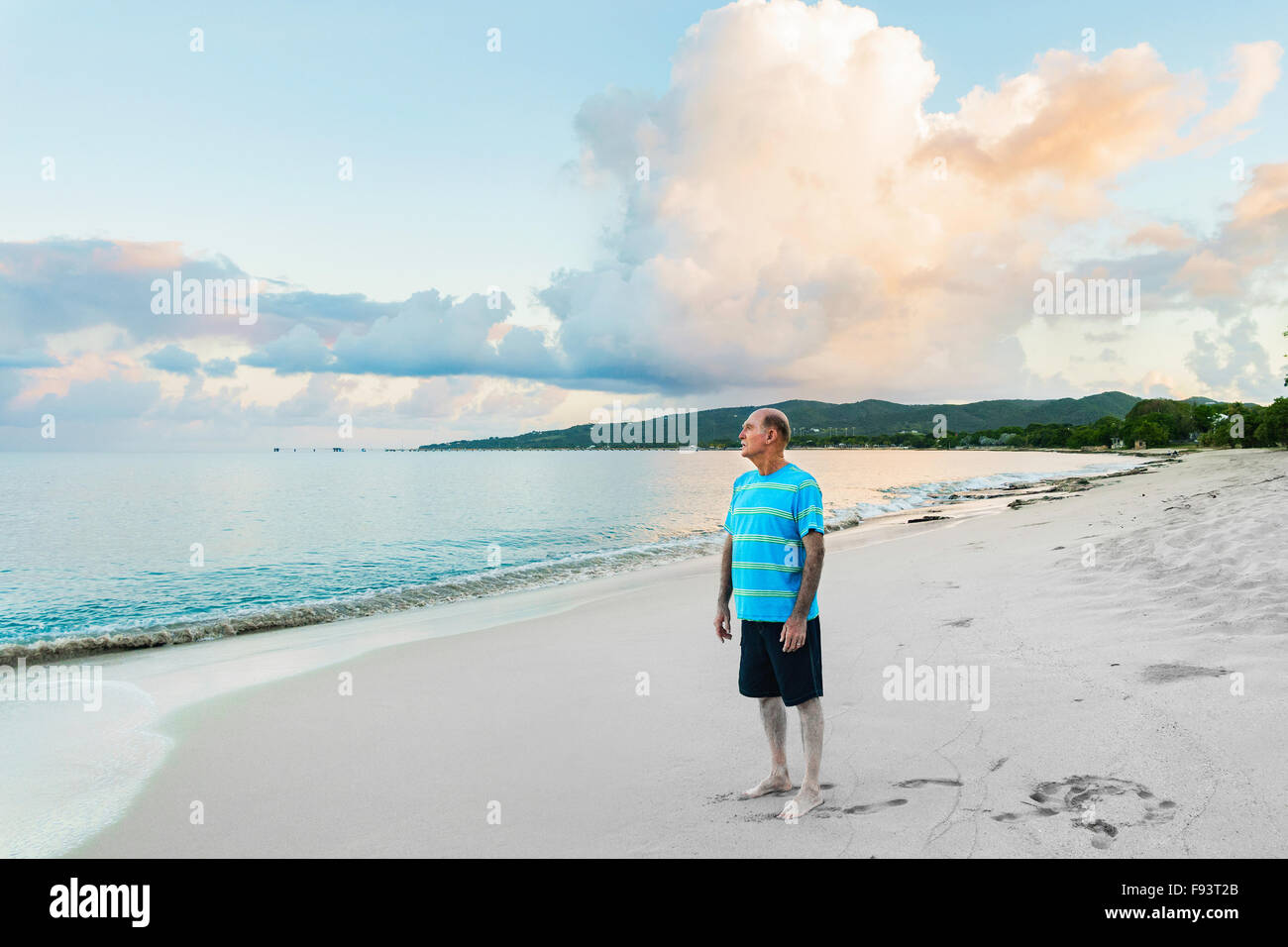 Ein 77-jähriger kaukasischen Mann am Strand bei Sonnenaufgang auf St. Croix, Amerikanische Jungferninseln. Stockfoto