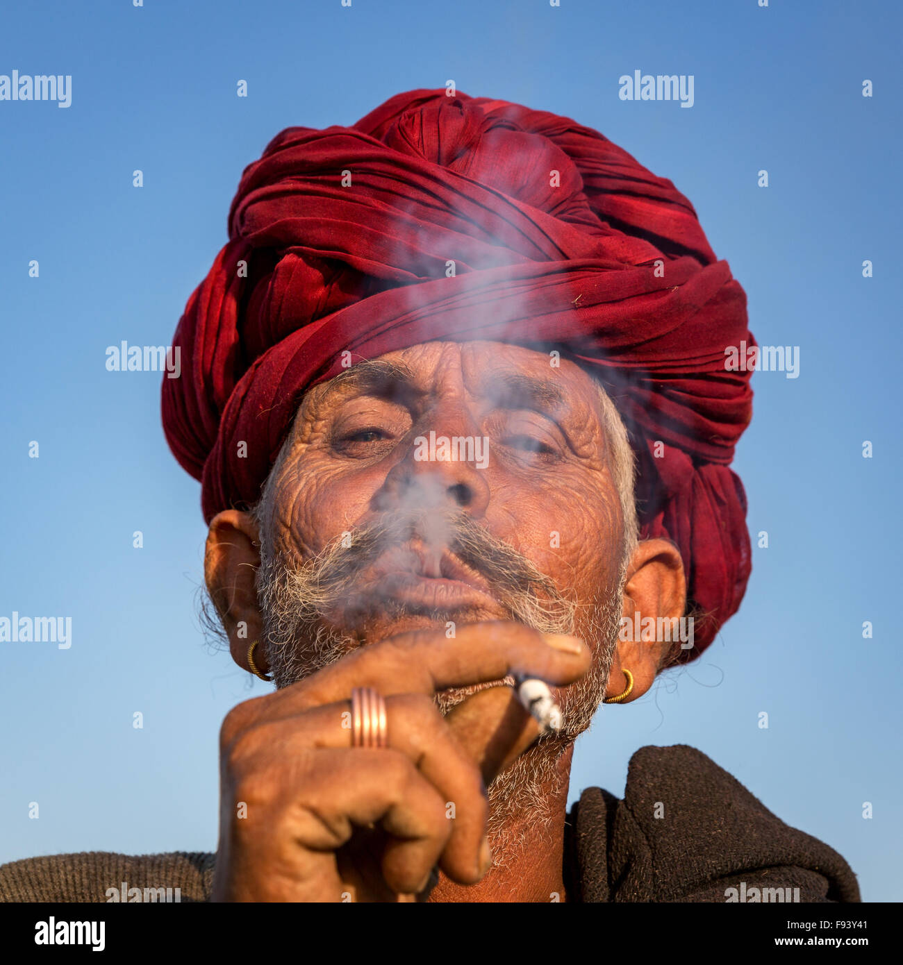 Porträt von einem senior Rajasthani-Rauchen und mit einem roten Turban, Pushkar, Rajasthan, Indien Stockfoto