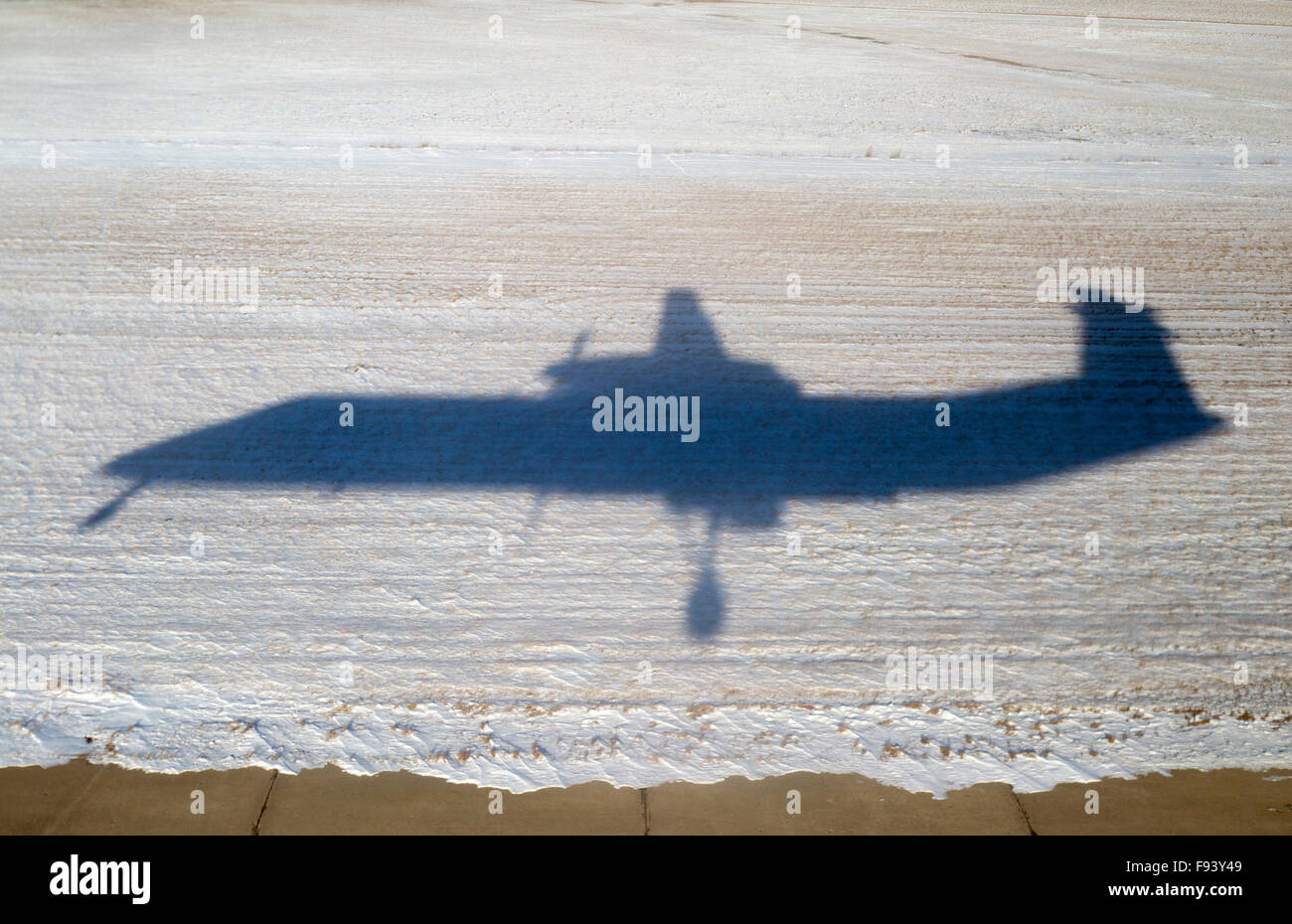 Schatten der Air Canada Bombardier Q400 Flugzeuge landen im Winter auf dem Saskatoon John G Diefenbaker International Airport auf einer Start- und Landebahn neben einem verschneiten Feld Stockfoto