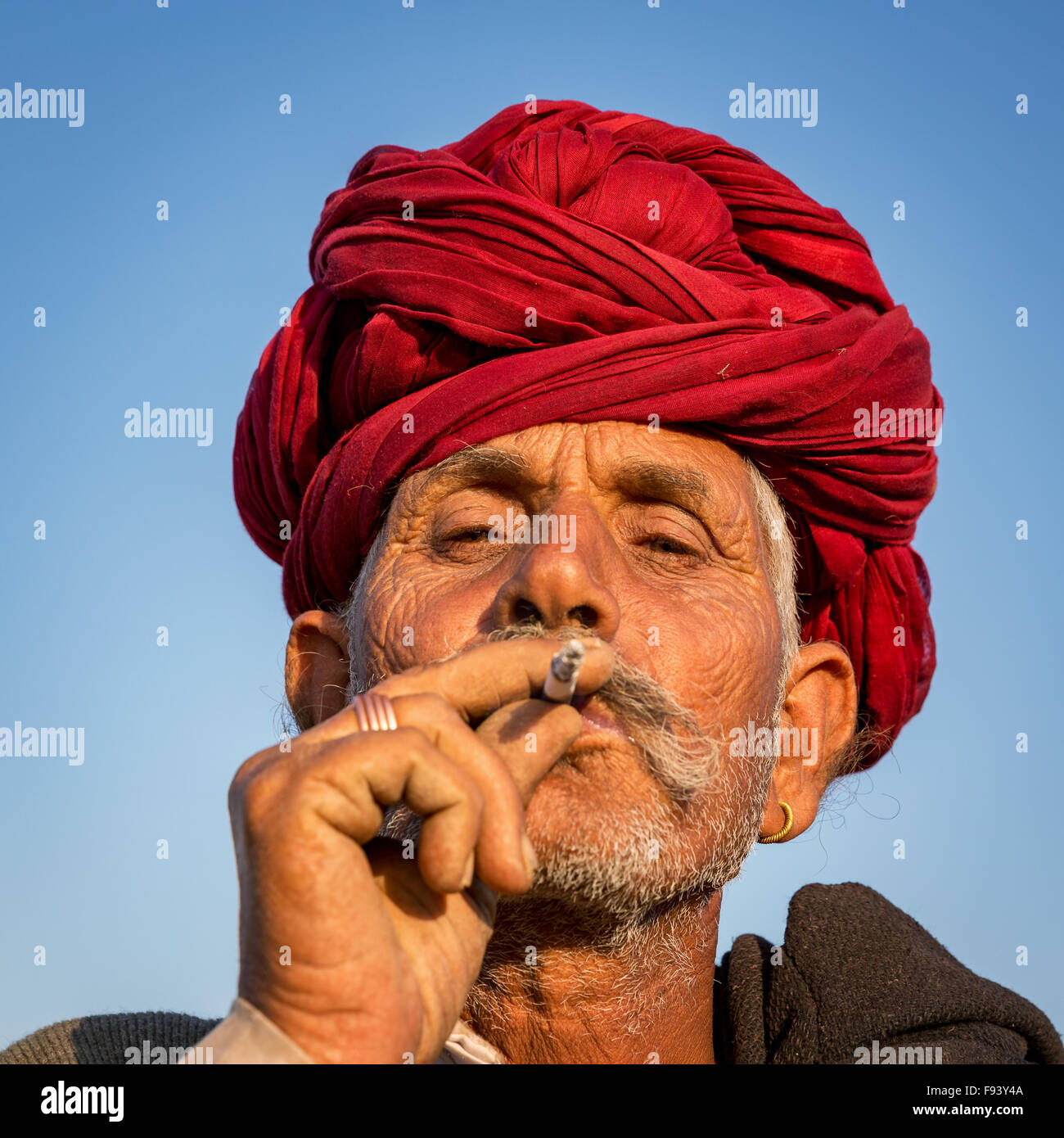 Porträt von einem senior Rajasthani-Rauchen und mit einem roten Turban, Pushkar, Rajasthan, Indien Stockfoto