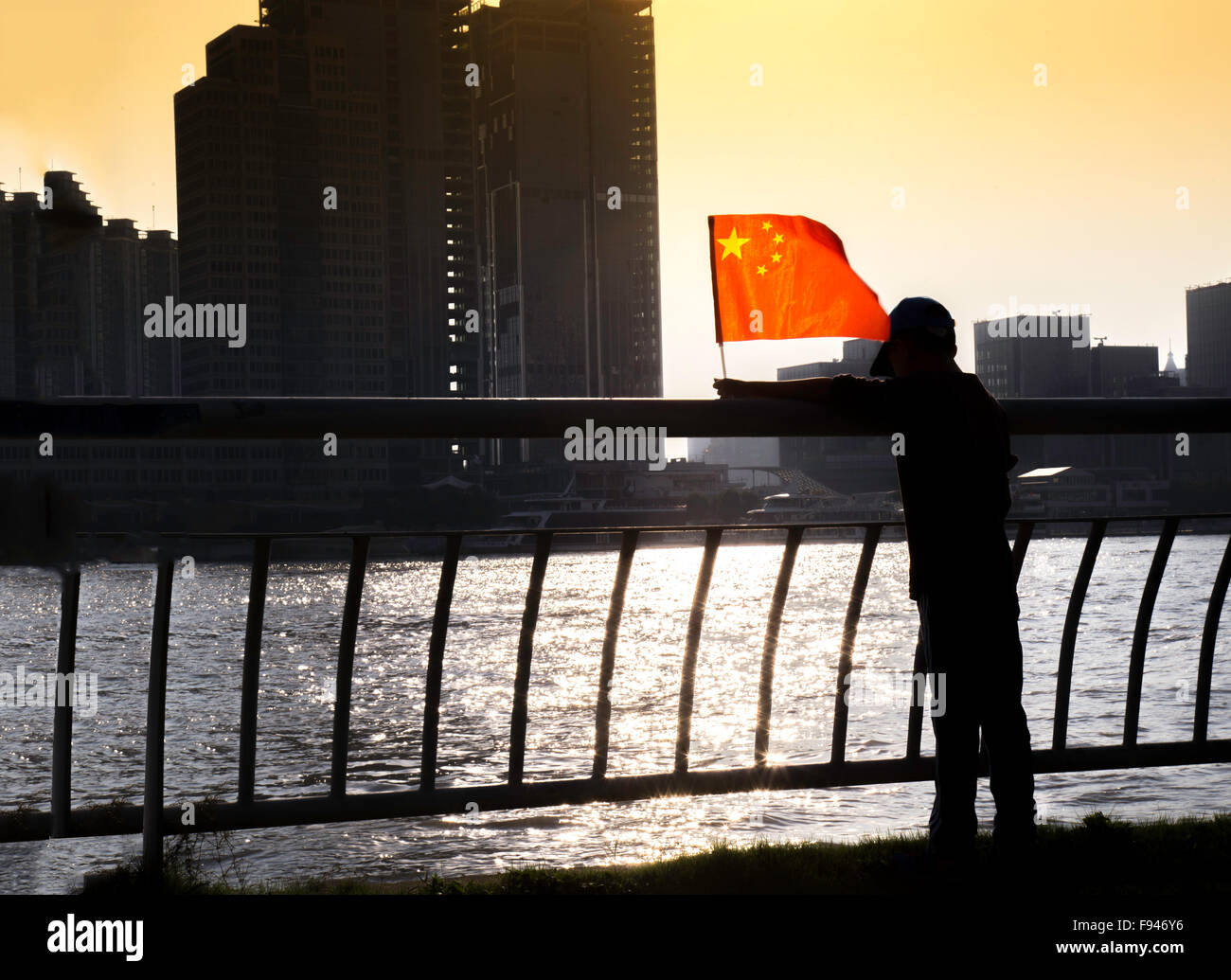 Silhouette eines kleinen Jungen winken chinesische Flagge am Nationalfeiertag starrte in den Huangpu-Fluss in Shanghai Stockfoto