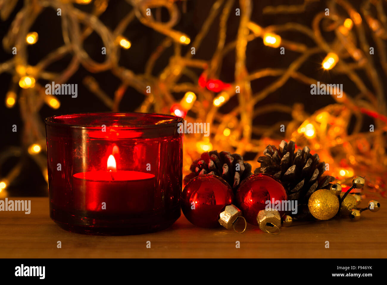 Kerze und Weihnachten Dekoration vor unscharfen Lichter auf Holztisch Stockfoto