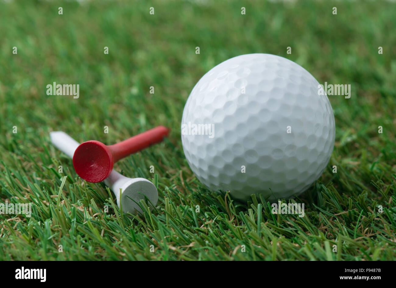 Golfball mit Tee auf dem Rasen Stockfoto
