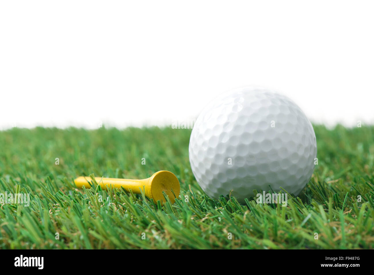 Golfball mit Tee auf dem Rasen Stockfoto