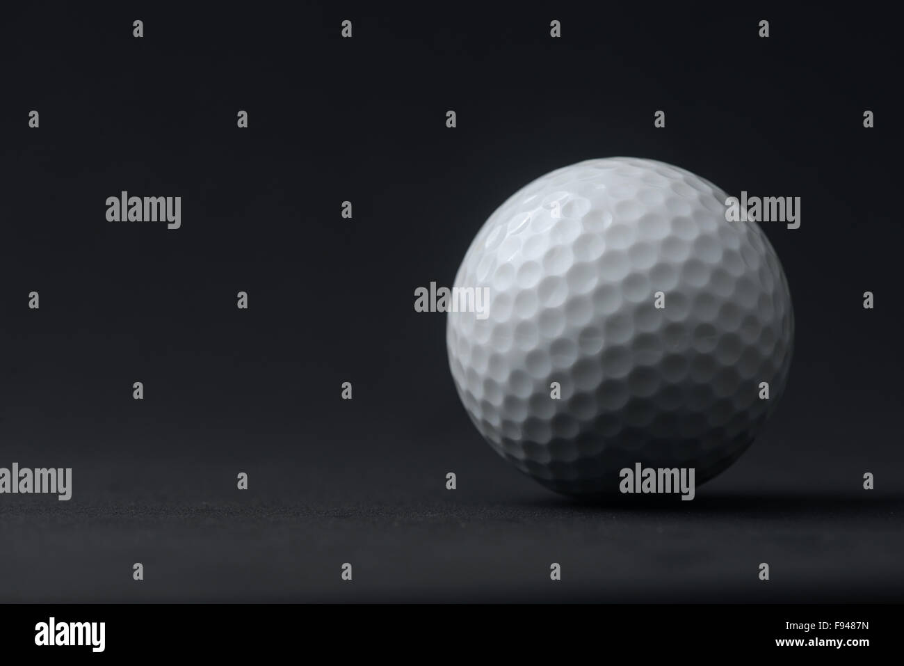Golfball auf schwarzem Hintergrund Stockfoto