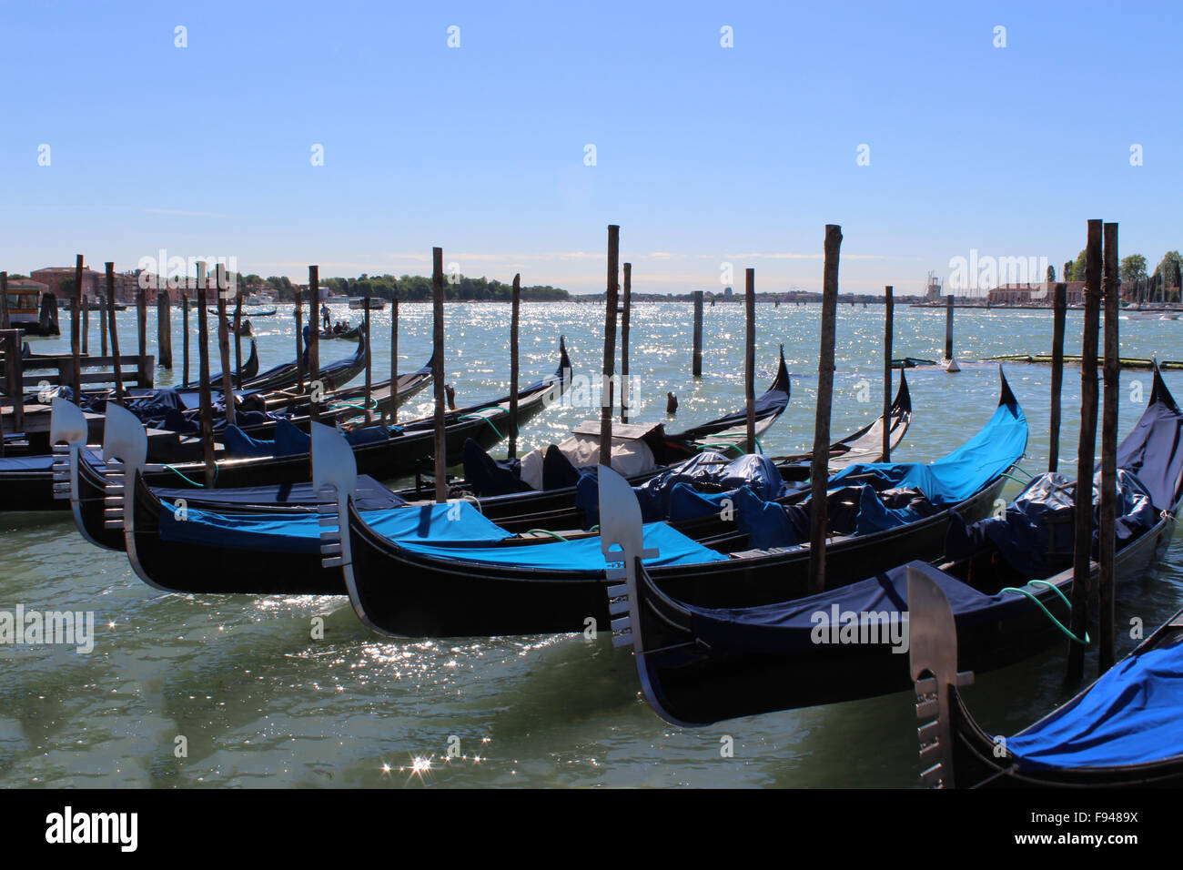 Gondeln in Venedig mit blauem Himmel aufgereiht Stockfoto