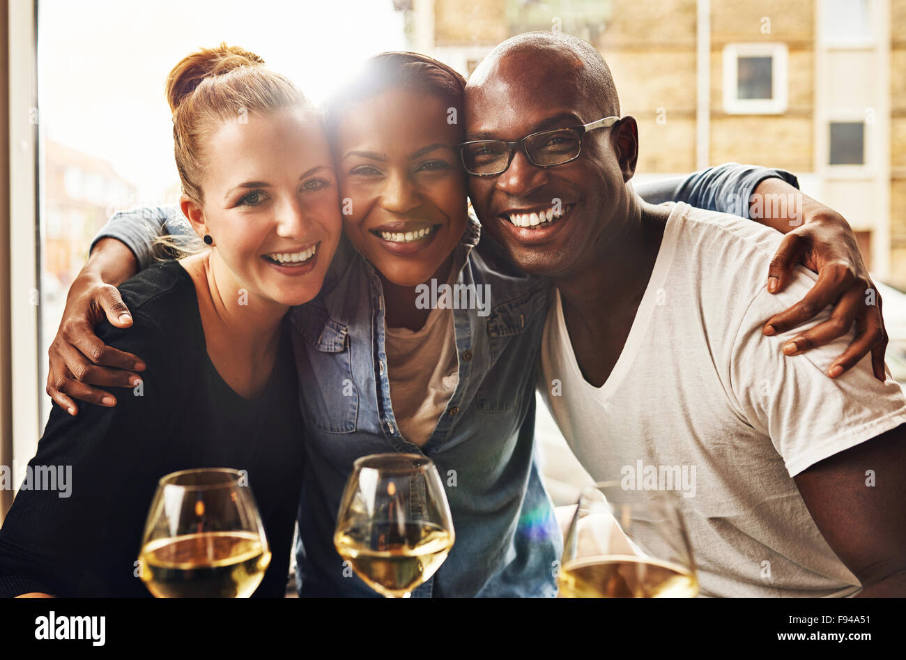 Drei ethnischen beste Freunde lächelnd an Kamera und umarmen Stockfoto