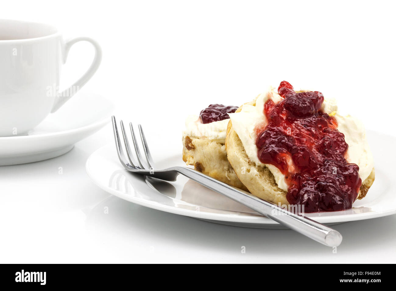 Hausgemachte Scones mit Erdbeer-Marmelade und Clotted Cream, oft mit einer Tasse Tee serviert. Als ein Cream Tea bekannt. Stockfoto