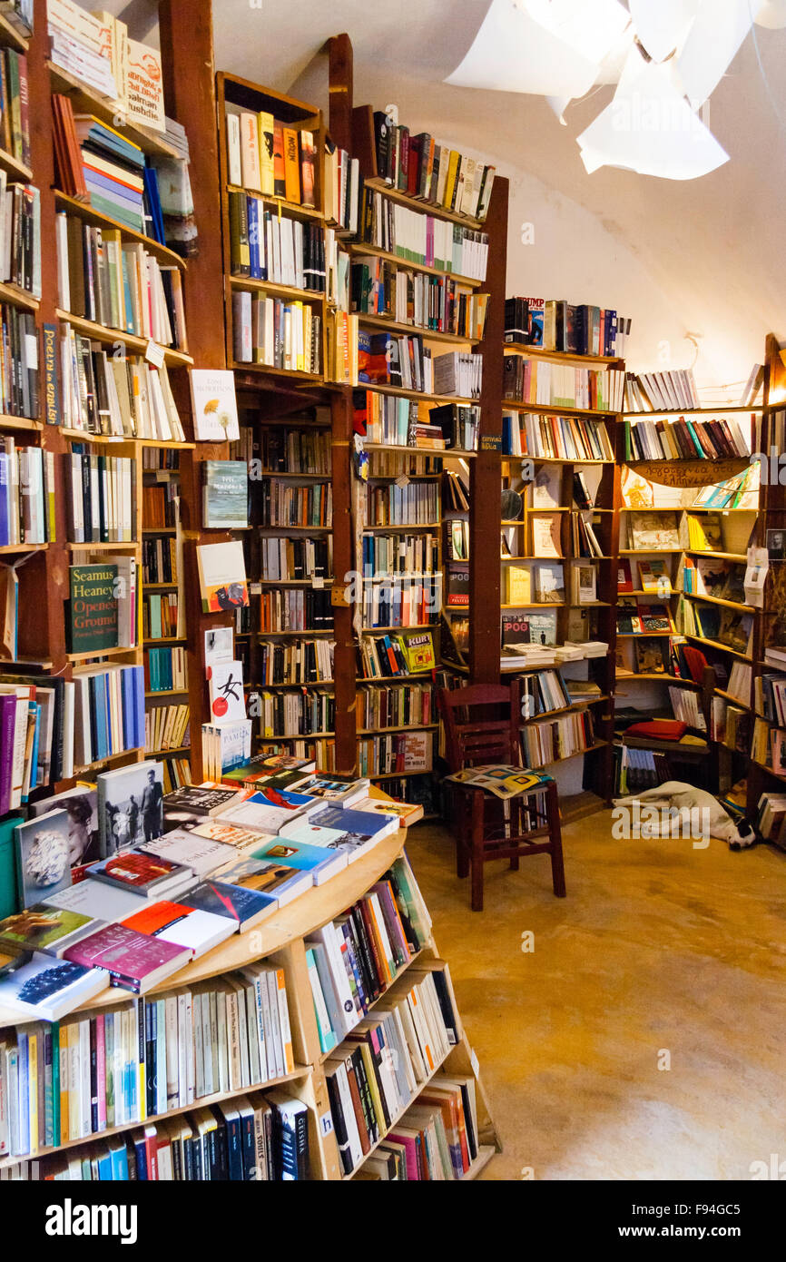 Santorini, Oia. Atlantis second hand Buchladen. Interieur mit Wänden in Holz Regale voller Bücher, Hund Festlegung in der Ecke schlafen. Stockfoto