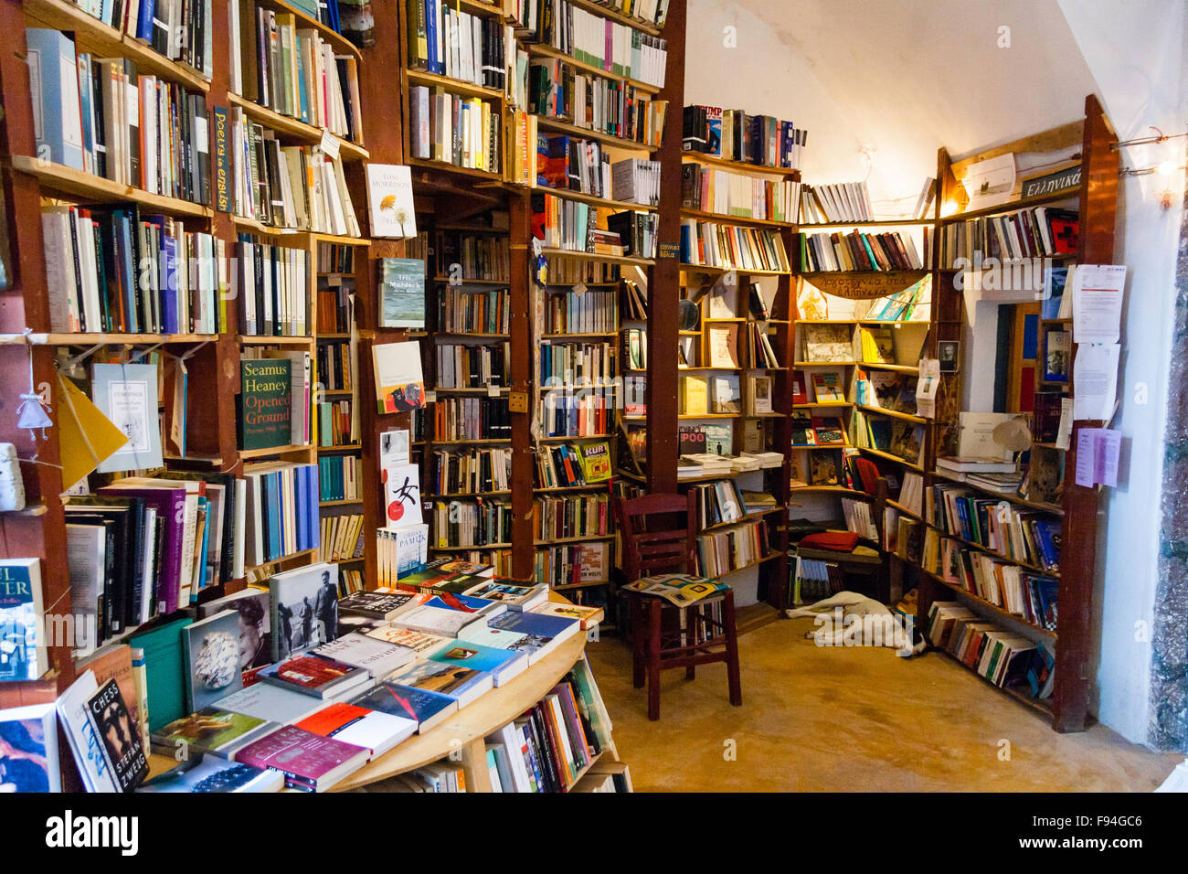Santorini, Oia. Atlantis second hand Buchladen. Interieur mit Wänden in Holz Regale voller Bücher, Hund Festlegung in der Ecke schlafen Stockfoto