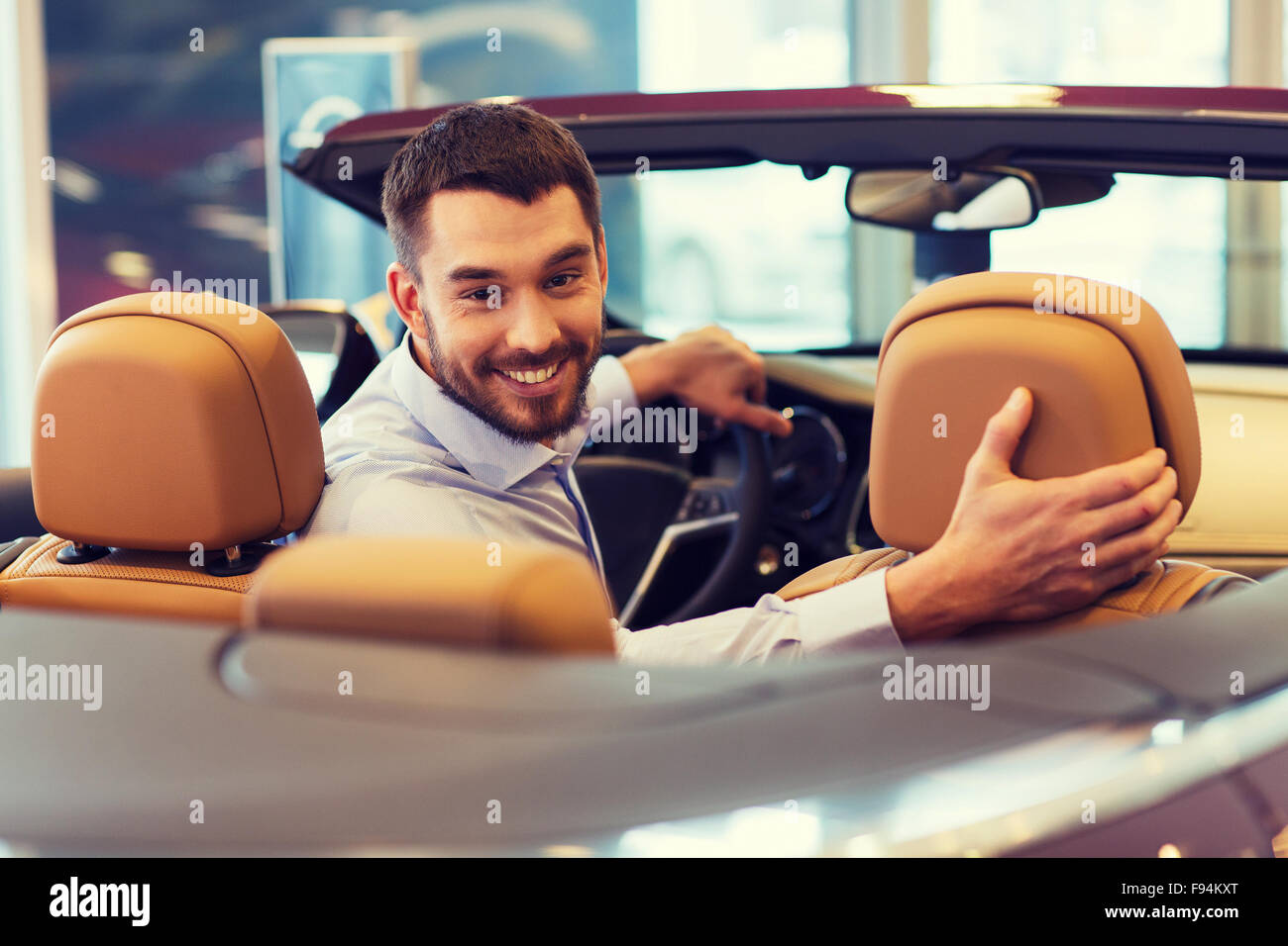 glücklicher Mann sitzen im Auto am Auto Show oder salon Stockfoto