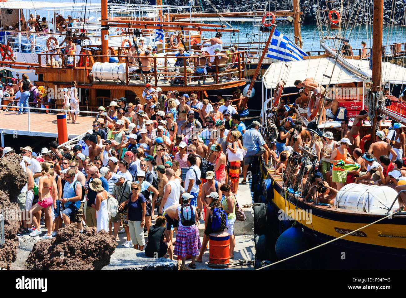 Santorini. Erinia Bay, Nea Kameni. Ausflug Boote am Steg vertäut verpackt mit Massen von Touristen Ein- und Aussteigen auf dem Vulkan besuchen. Stockfoto Santorini. Erinia Bay, Nea Kameni. Ausflug Boote am Steg vertäut verpackt mit Massen von Touristen Ein- und Aussteigen auf dem Vulkan besuchen. Stockfoto