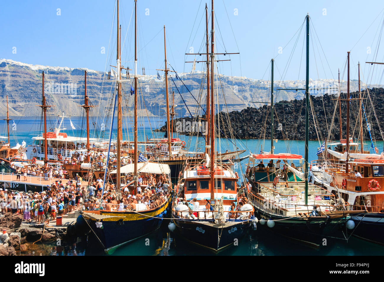 Santorini. Erinia Bay, Nea Kameni. Ausflug Boote am Steg vertäut verpackt mit Massen von Touristen Ein- und Aussteigen auf dem Vulkan besuchen. Stockfoto Santorini. Erinia Bay, Nea Kameni. Ausflug Boote am Steg vertäut verpackt mit Massen von Touristen Ein- und Aussteigen auf dem Vulkan besuchen. Stockfoto