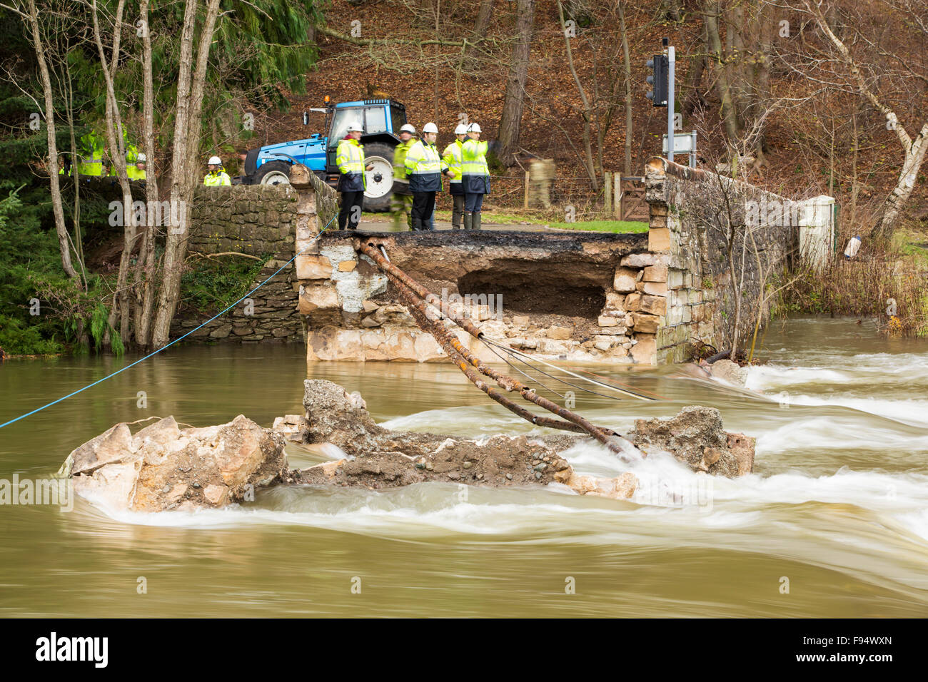 Pooley-Brücke, die den Fluss Eamont unter Ullswater überspannt hatten die Elemente standgehalten, da wurde es im Jahre 1764 gebaut, aber es war kein Spiel für Sturm Desmond und wurde völlig zerstört. Foto auf Dienstag, 8. Dezember 2015, mit British Telecom Ingenieure versuchen, Kommunikation auf die andere Seite wiederherstellen, nachdem sie von der Brückeneinsturz geschnitten wurden. Der Sturm setzen einen neuen britischen Rekord für Rainfsll Summen an einem Tag mit 341,4 mm in 24 Stunden fallen. Stockfoto