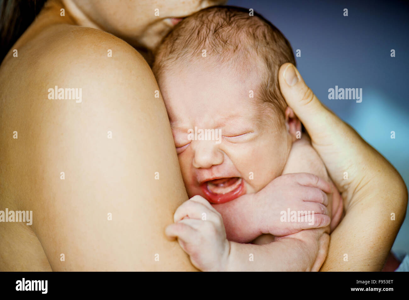 Neugeborenes Baby weint in Mutter Händen indoor Stockfoto
