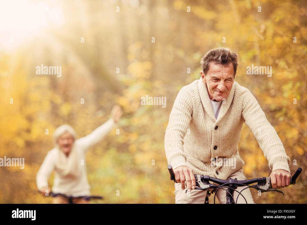Aktive Senioren mit Fahrrad in der herbstlichen Natur. Sie haben Spaß im Freien. Stockfoto