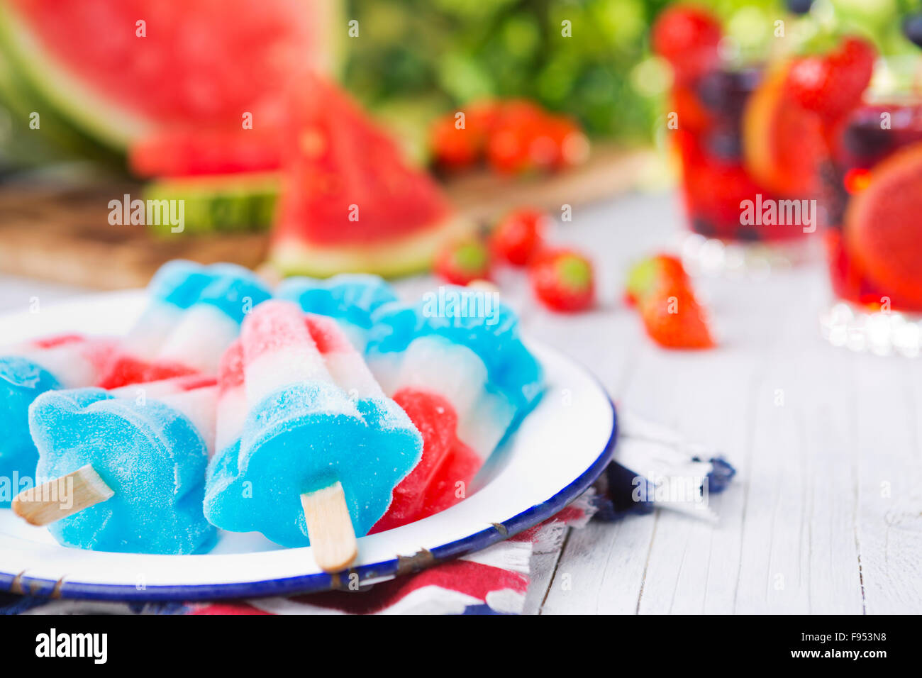 Hausgemachte rot-weiß-blauen Eis am Stiel auf einen Tisch im Freien mit erfrischenden Limonade im Hintergrund. Stockfoto