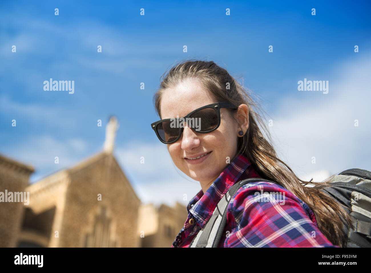 Hübsche junge weibliche Touristen mit Rucksack vor der Kirche in Barcelona, Spanien. Stockfoto