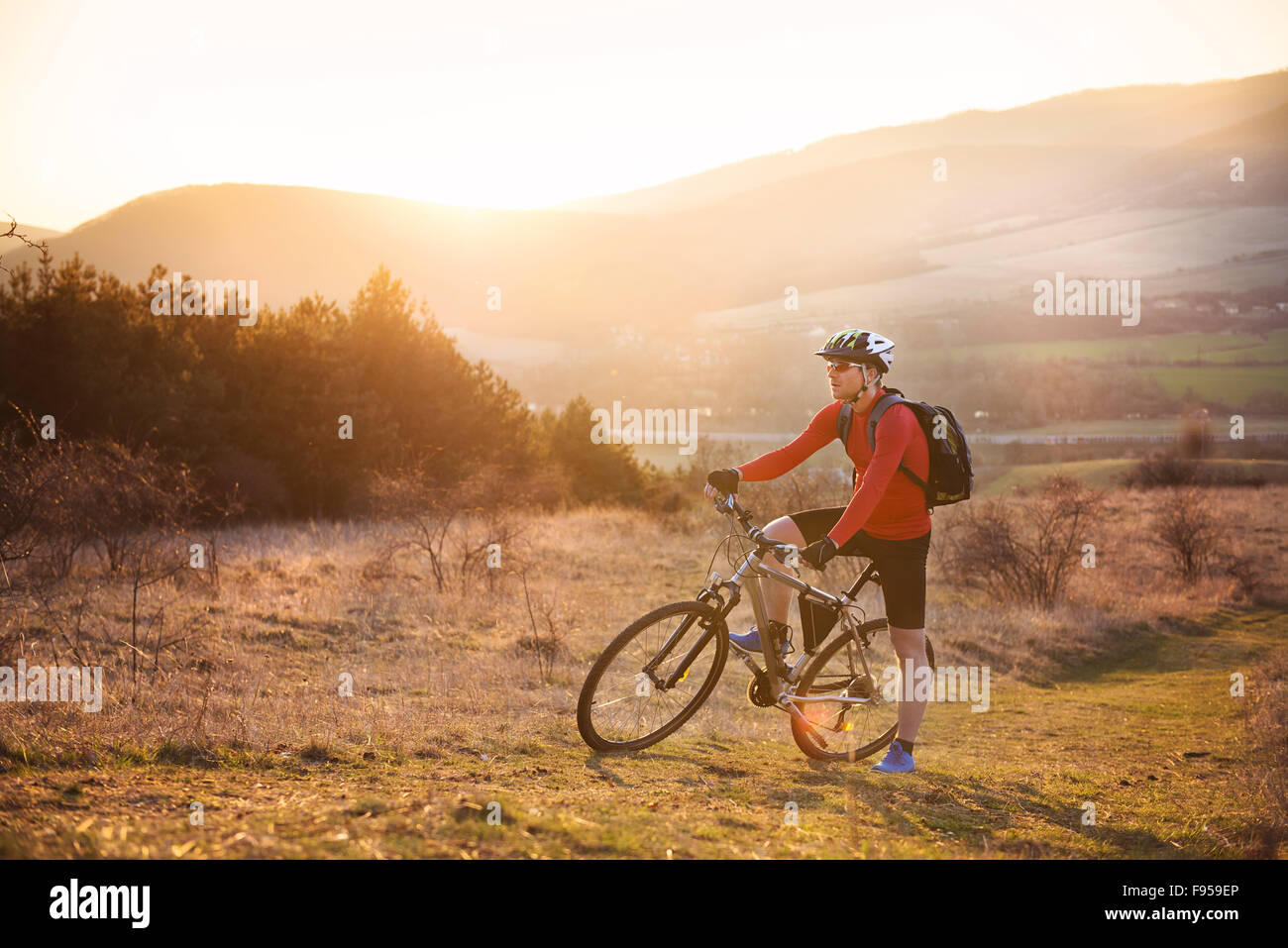 Radfahrer-Mann Reiten Mountainbike auf Outdoor-Parcours im sonnigen Wiese Stockfoto