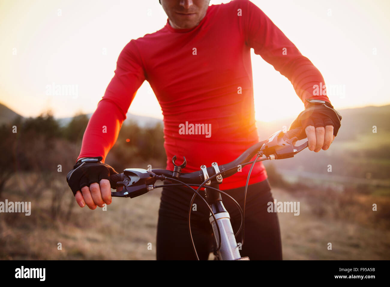 Detail der Radfahrer Mann auf Mountainbike auf Outdoor-Parcours im sonnigen Wiese Stockfoto