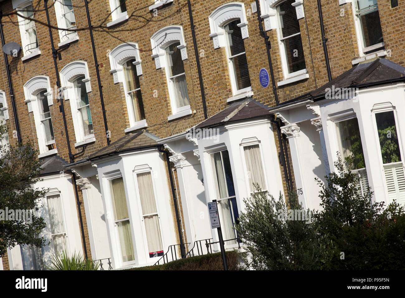 Hammersmith, London. Seitlicher Blick auf Reihenhäuser in einer Wohnstraße in Hammersmith. Erkerfenster. Ziegel auf der oberen Hälfte der Häuser verwendet. Stockfoto