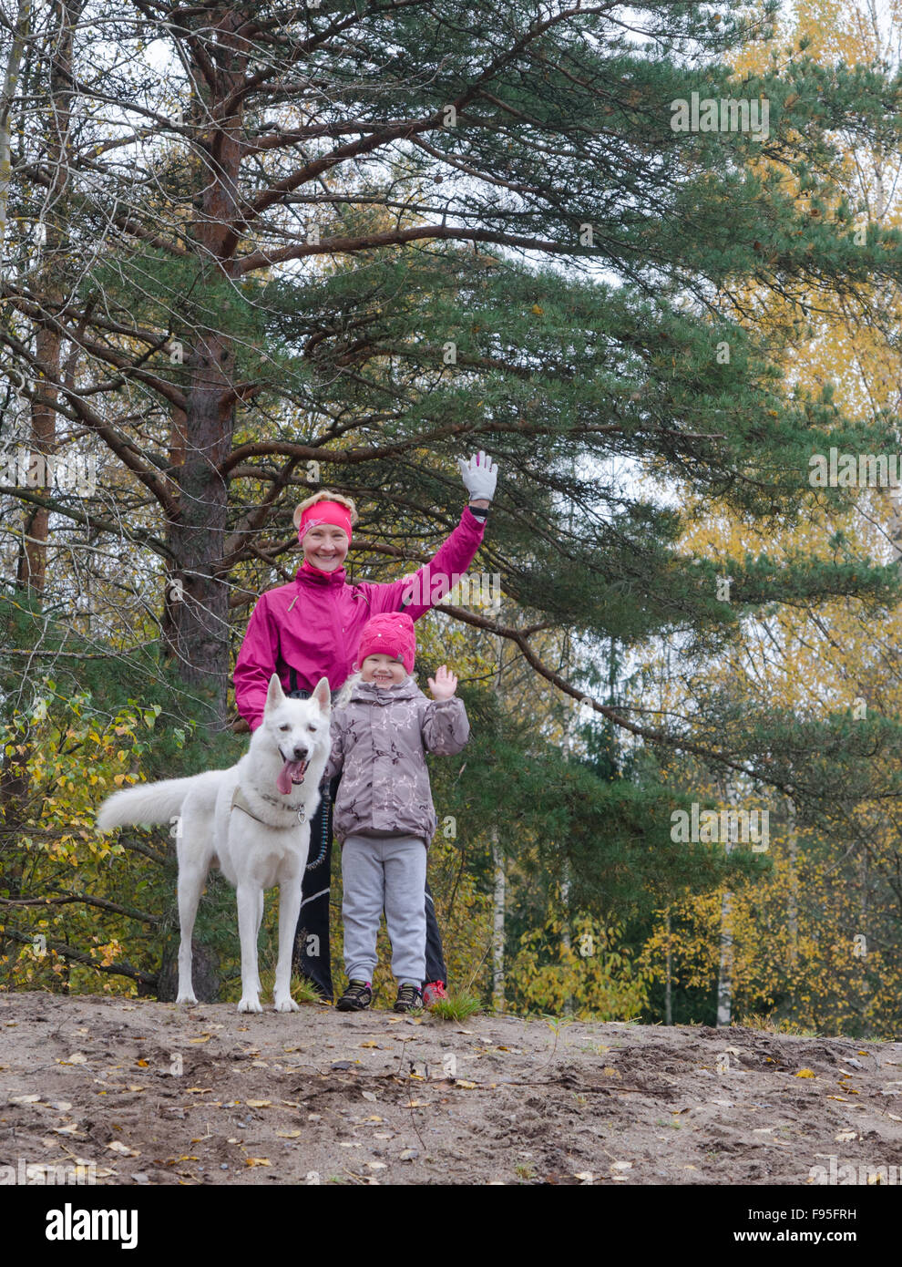Oma mit ihrer Enkelin und einen Hund-Spaziergang im Herbst Park Stockfoto