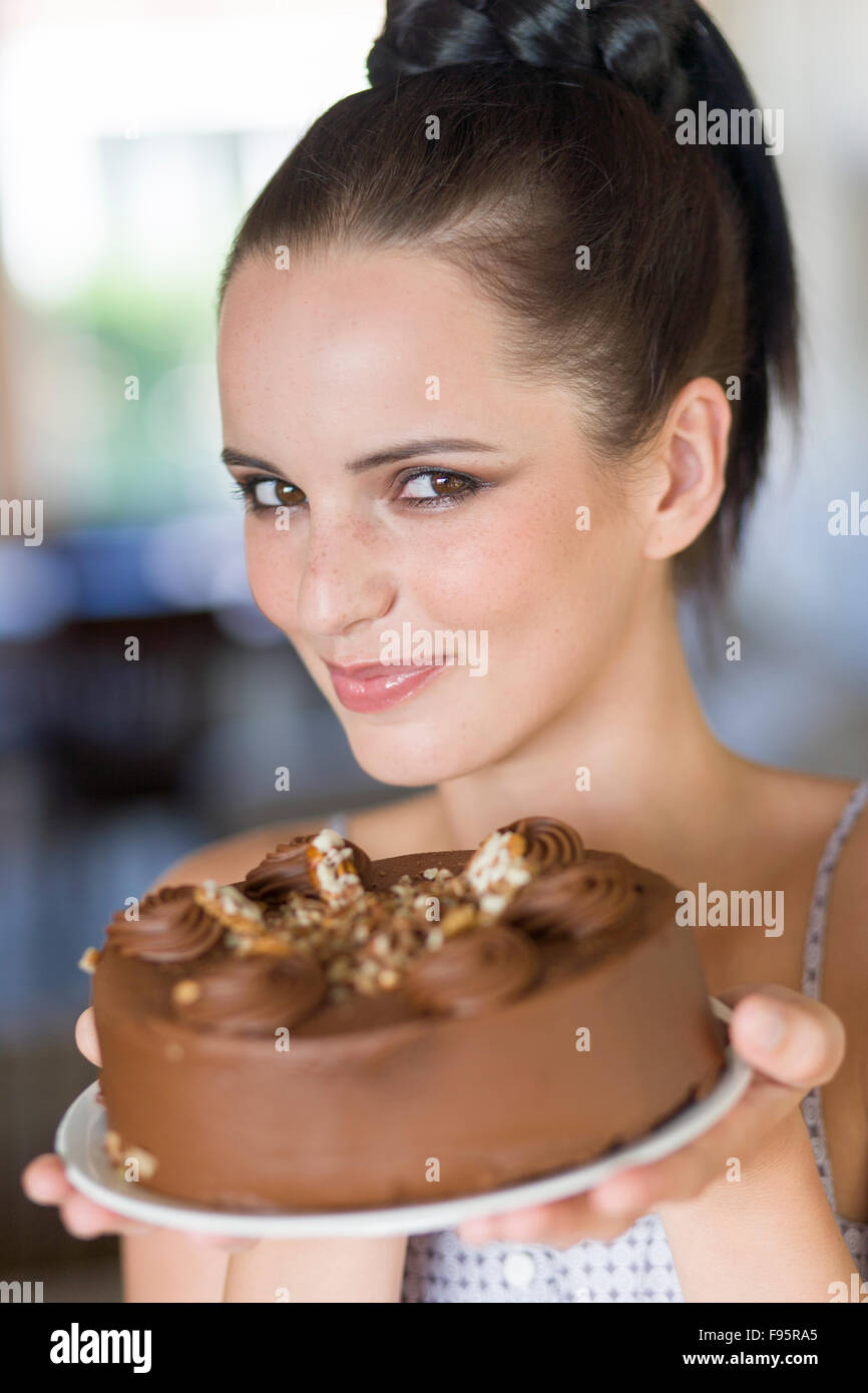 Junge Frau hält einen Schokoladenkuchen Stockfoto