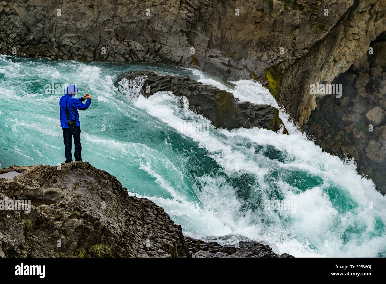 Mann, die Aufnahme von Bildern mit einem Smartphone an Godafoss Wasserfall, Island Stockfoto
