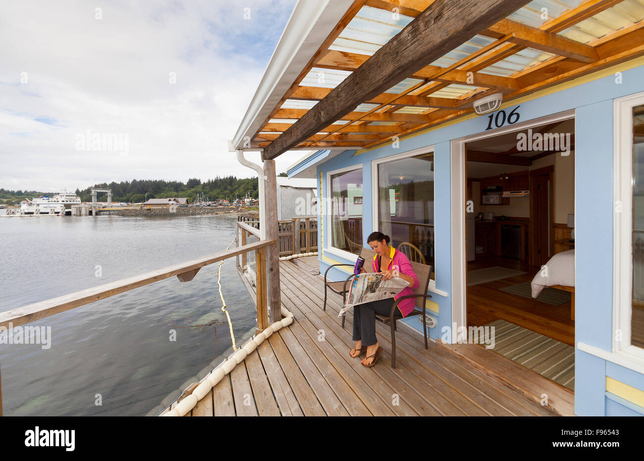 Ein Besucher des Inn Seine Boot entspannt auf dem Balkon am Wasser.  Alert Bay. Stockfoto