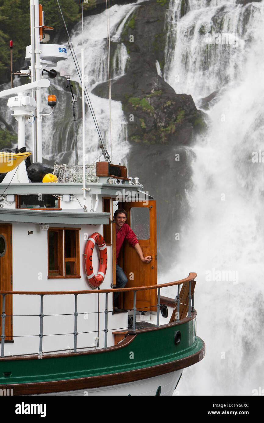 Captain Luke Hyatt posiert für ein Bild auf der Basis eines Wasserfalls in Kynoch Bucht.  Zentral-British Columbia-Küste, Brite/Britin Stockfoto