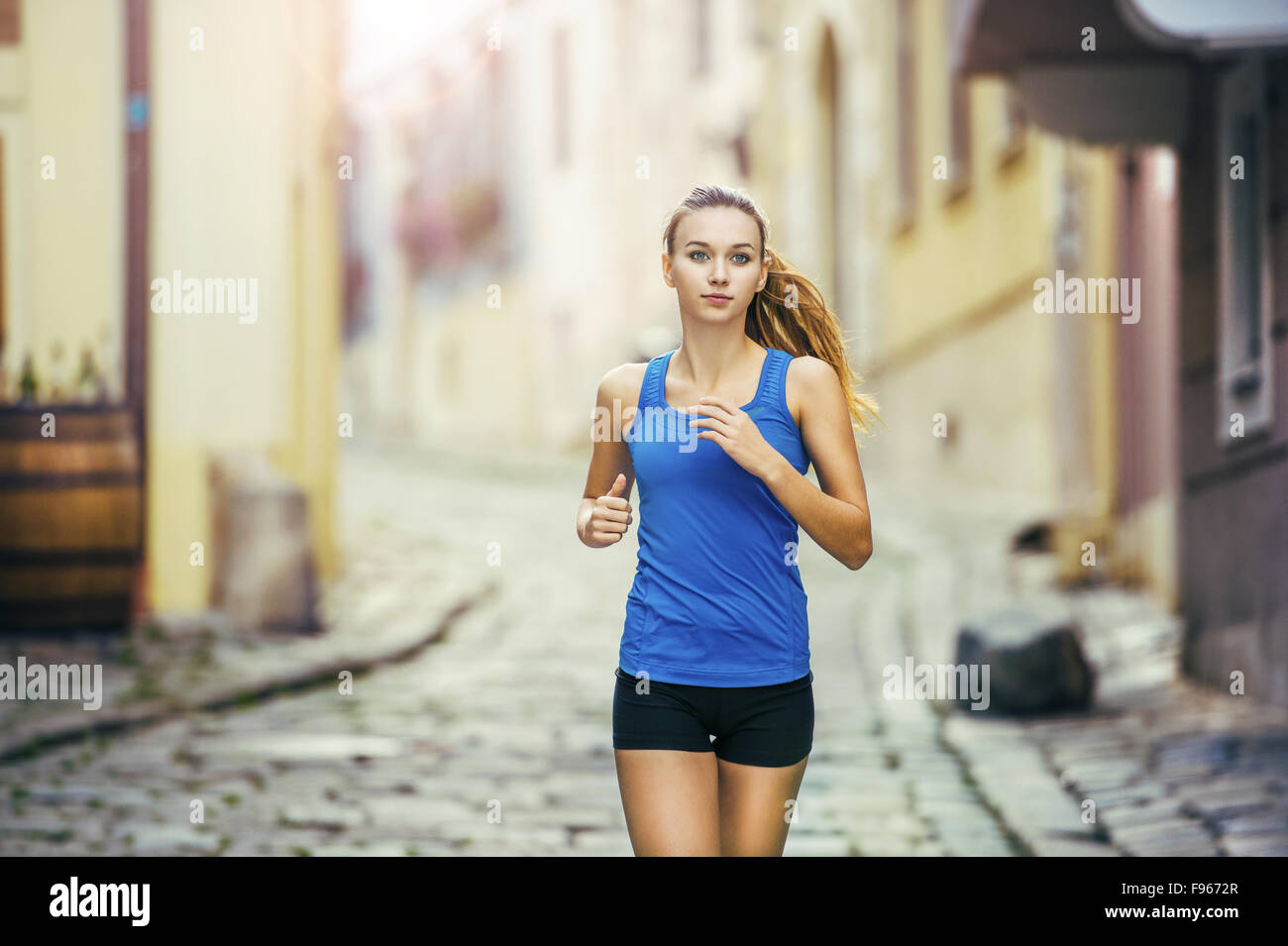 Junge weibliche Läufer ist auf gefliesten Pflaster Altstadt auf Center Joggen. Gesunde Lebensweise. Stockfoto