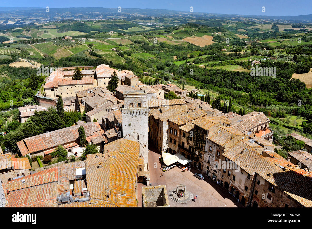 Blick von oben auf San Gimignano mit dem Brunnen der Piazza della Cisterna und die umliegenden Hügel, Toskana, Italien Stockfoto