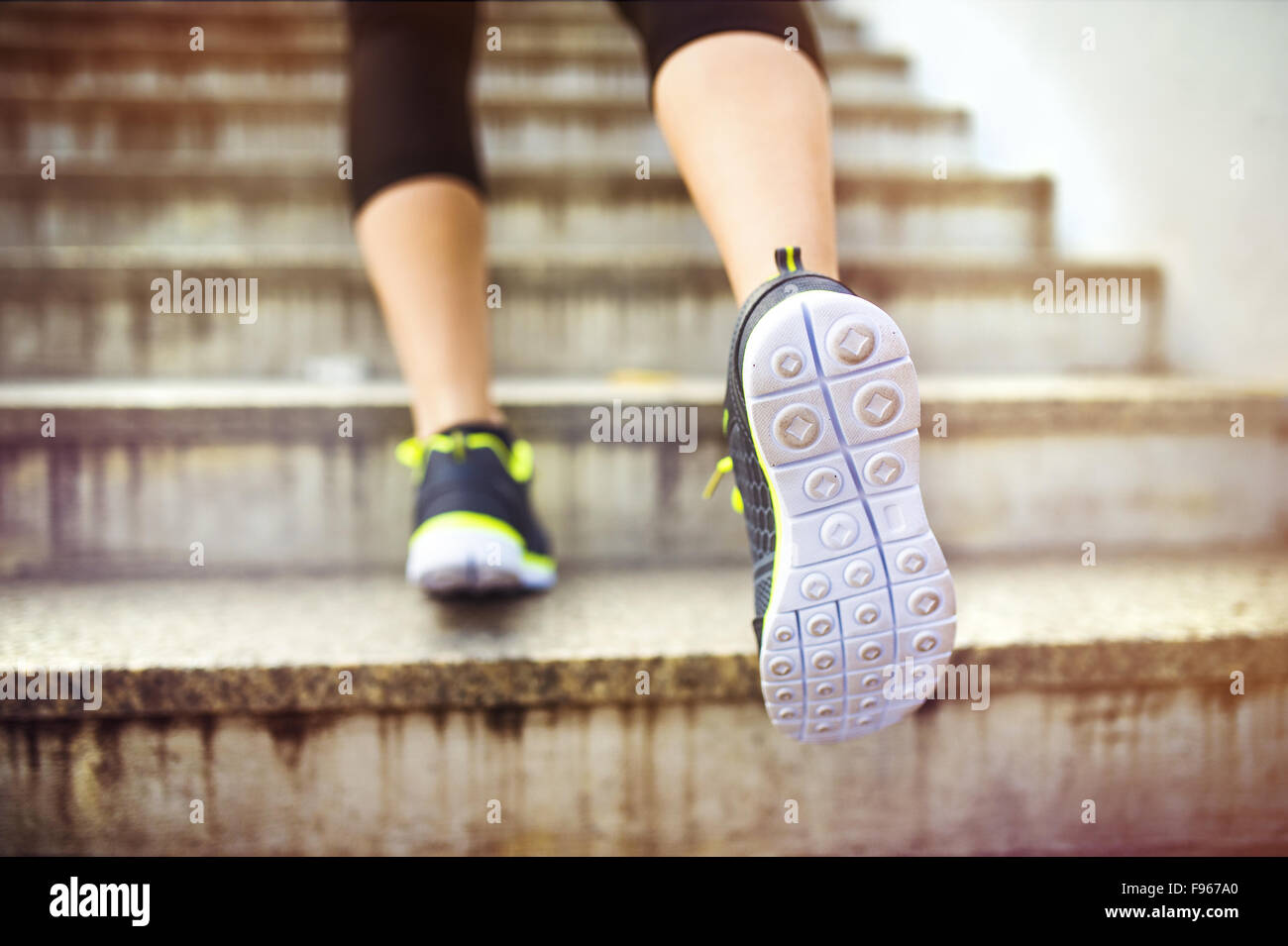 Weibliche Läufer laufen die Treppen in der Innenstadt, Closeup auf Schuhe Stockfoto