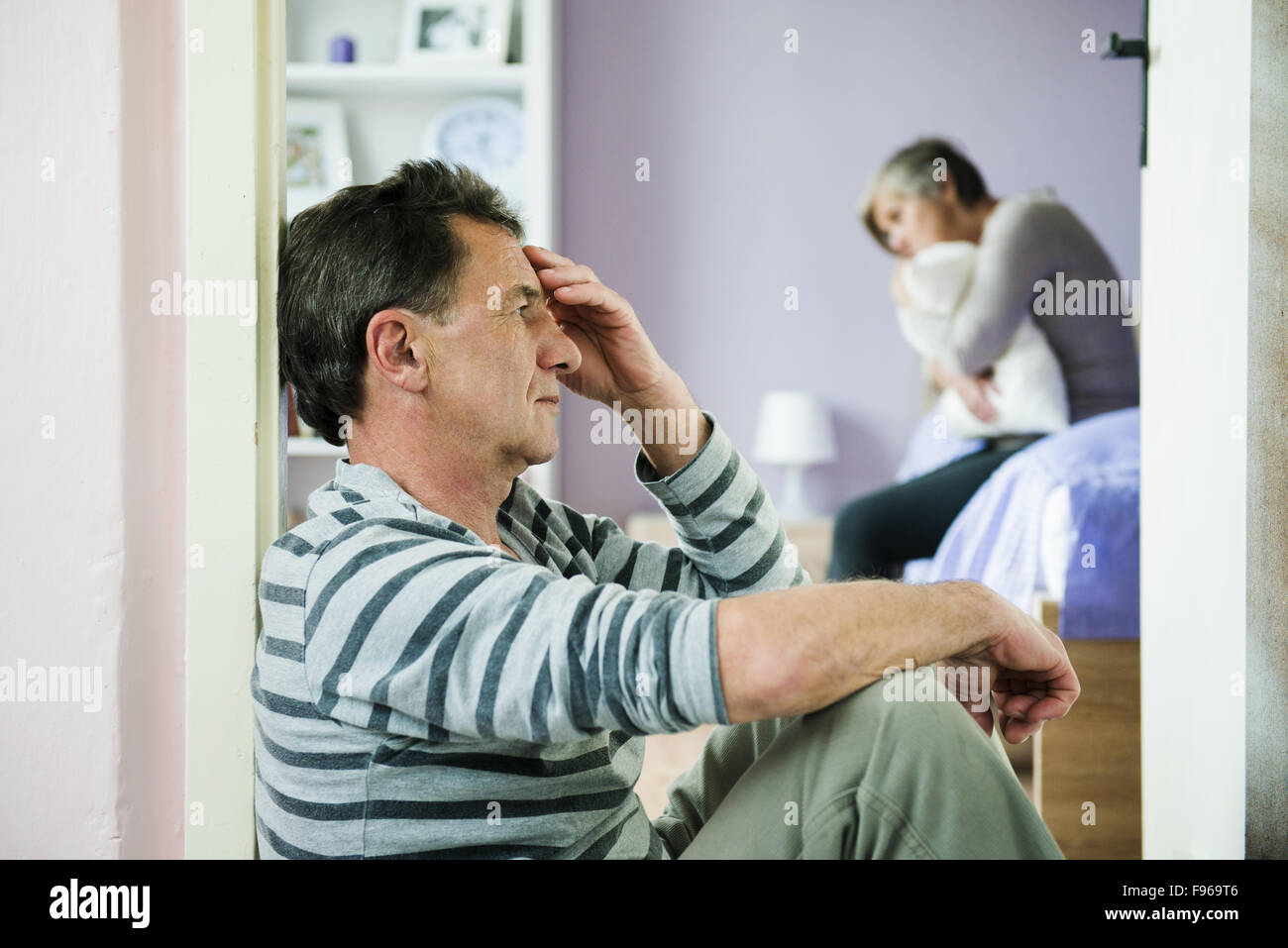 Reife Frau aufgewirbelt auf dem Bett hat ein Mann Angst vor. Frau ist Opfer von häuslicher Gewalt und Missbrauch. Stockfoto