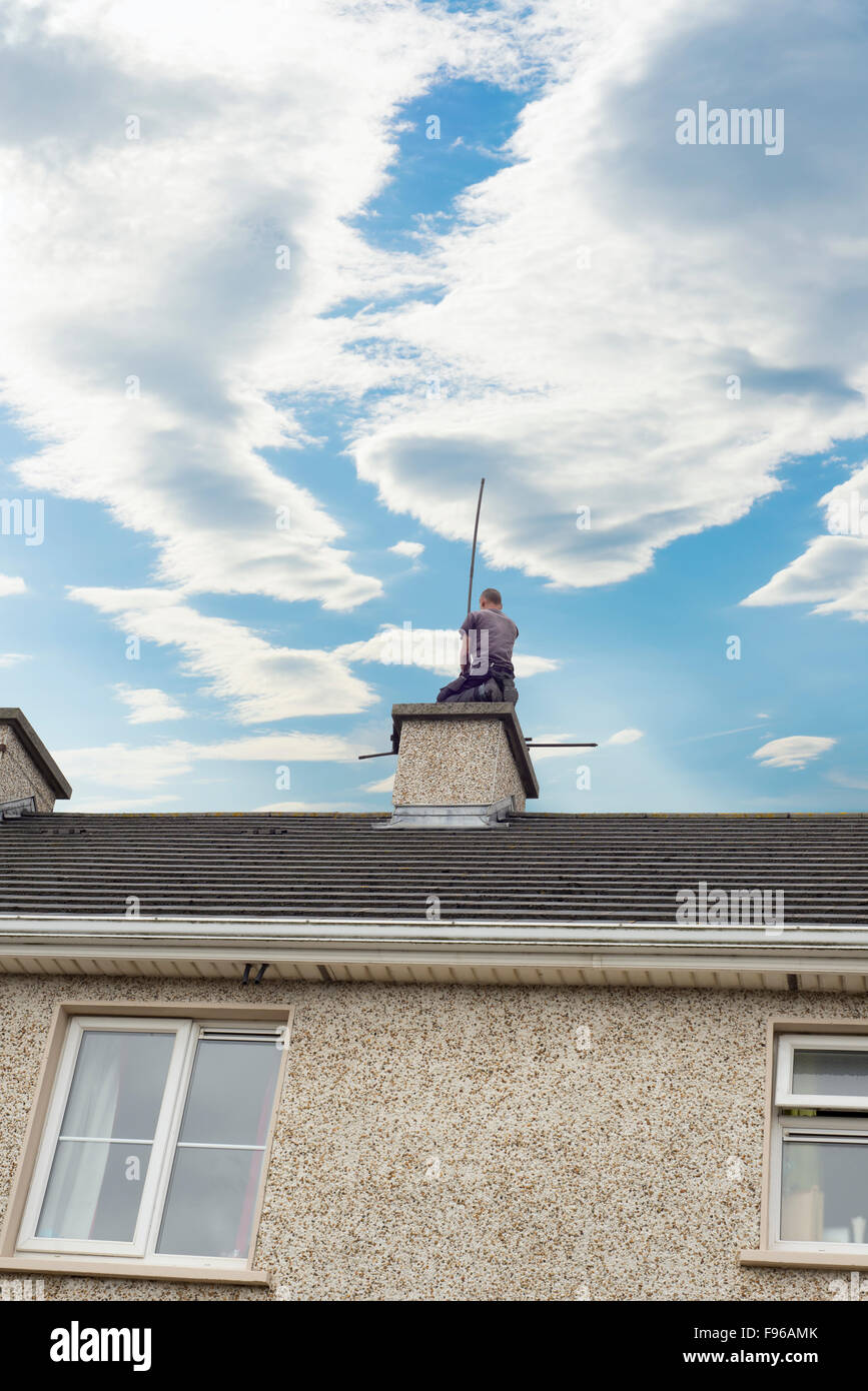 Schornsteinfeger beschäftigt Reinigung Schornstein auf einem Haus Stockfoto