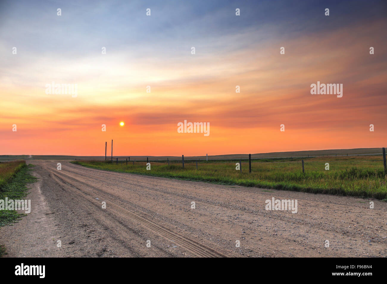 Sonnenuntergang, südlichen Saskatchewan, Prärie, Schotterstraße, eingezäunten Weide, Kanada, RM Bateman, Reifenspuren Stockfoto