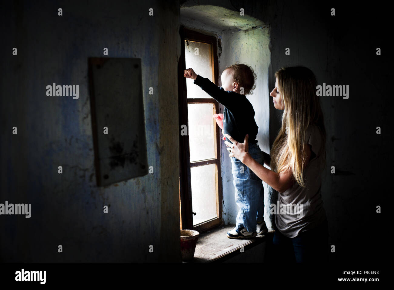 Glückliche junge Mutter mit ihrem Sohn im alten Haus Stockfoto