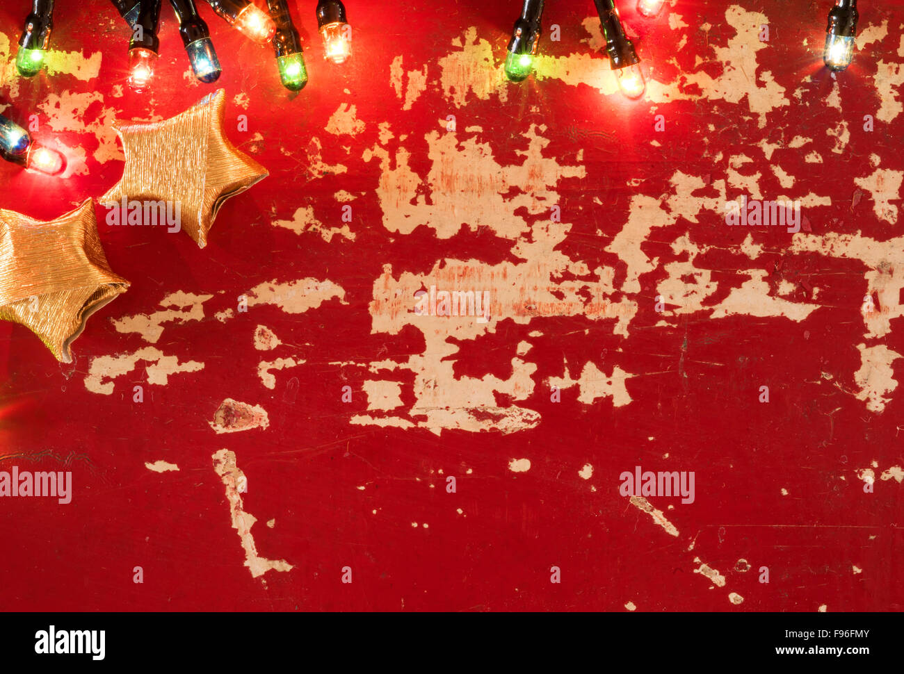 Urlaub Konzept Backdrop Vorlage, Goldpapier Sterne Dekoration und Weihnachtsbeleuchtung auf leere retro Grunge Holz Hintergrund. Stockfoto