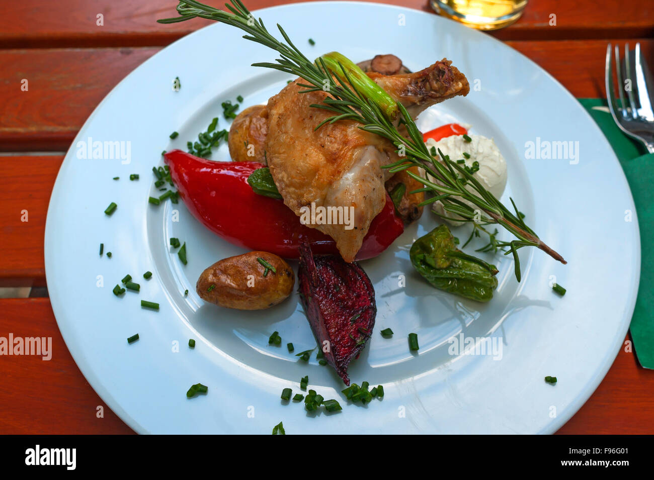 Hähnchenkeulen und Gemüse, garniert mit Rosmarin Stockfoto