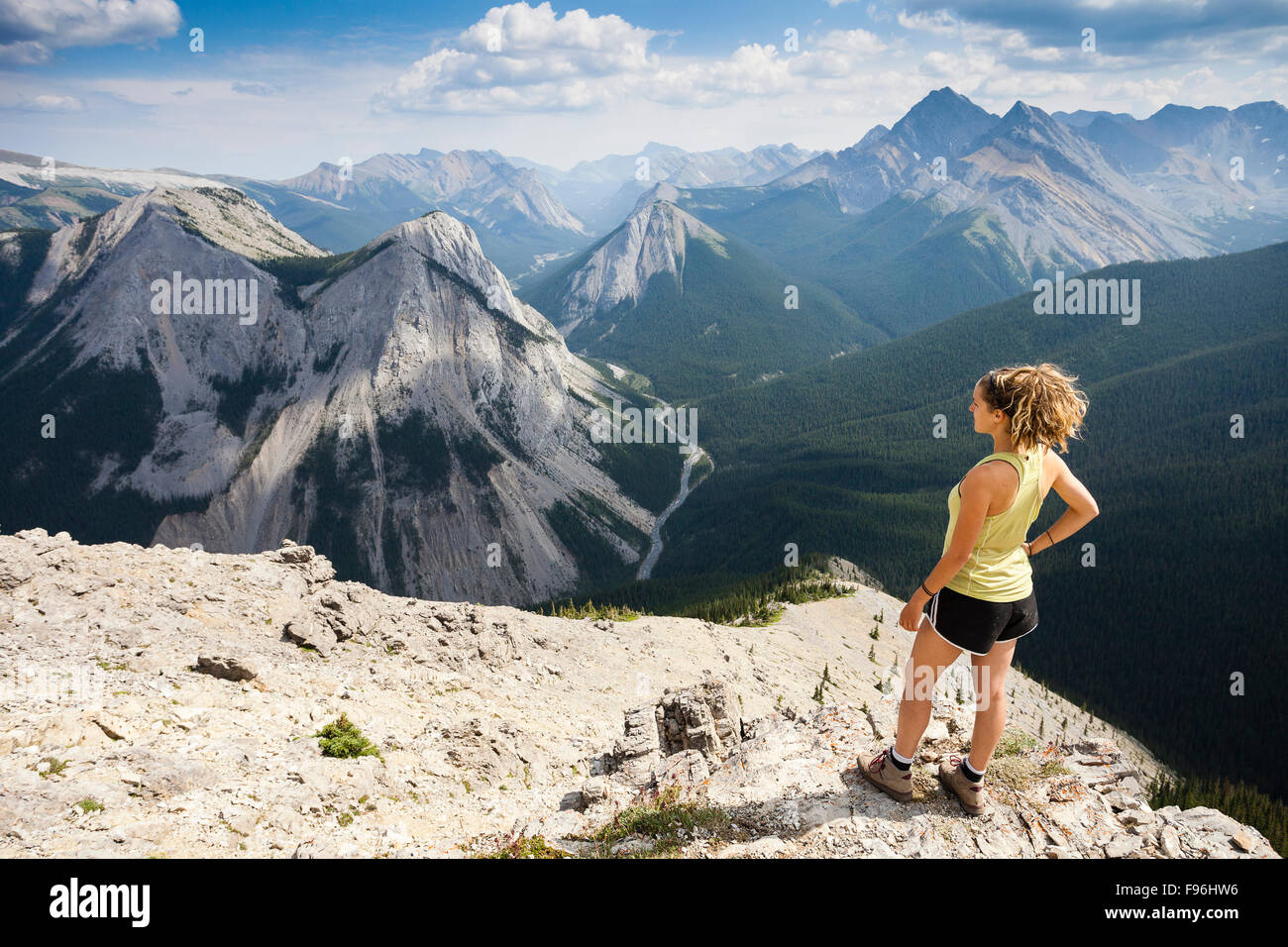 Eine junge Frau steht auf dem Gipfel des Sulphur Skyline Trail mit Blick auf die Rocky Mountains. Miette Hotsprings, Jasper Stockfoto