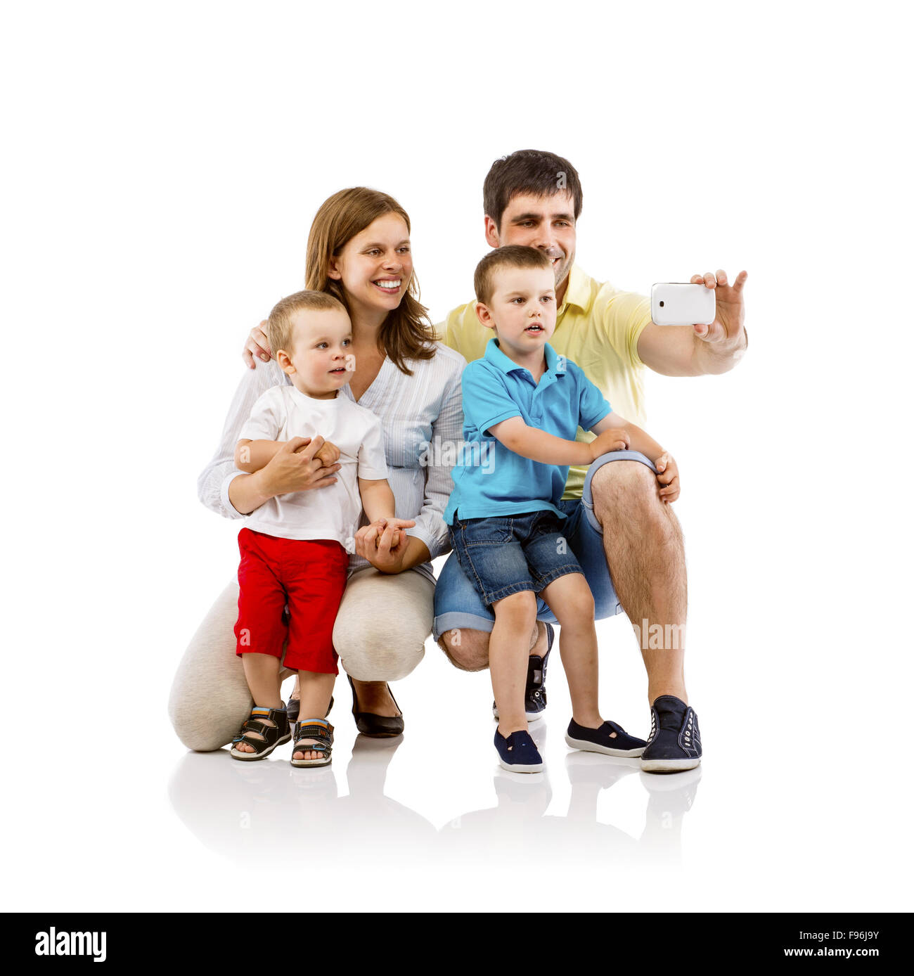 Porträt von die glückliche Familie mit zwei Kindern und schwangeren Mutter nehmen Selfie, isoliert auf weißem Hintergrund Stockfoto